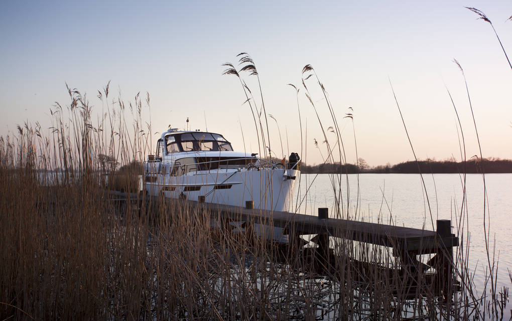 Super Lauwersmeer Sierra Lima ligt aangemeerd aan een steiger omringt door riet.